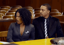 a man and a woman are sitting in a courtroom