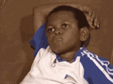 a young boy is laying on a couch and making a funny face