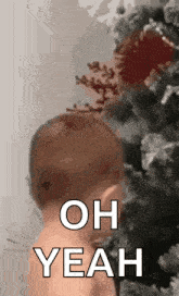 a baby is standing in front of a christmas tree .