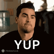 a man from schitts creek is making a funny face and the word yup is above him